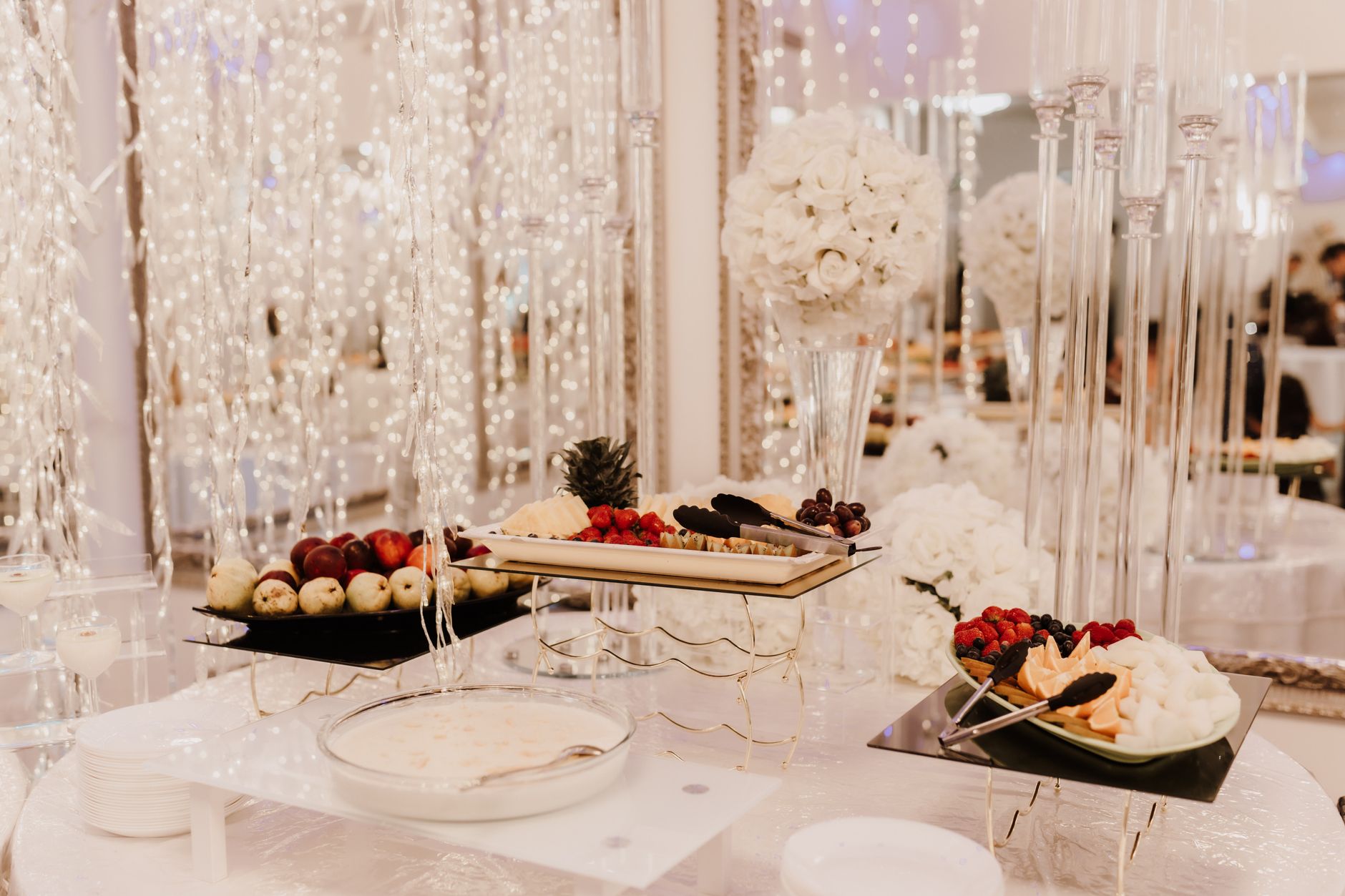 A beautiful wedding reception buffet featuring desserts and floral arrangements.