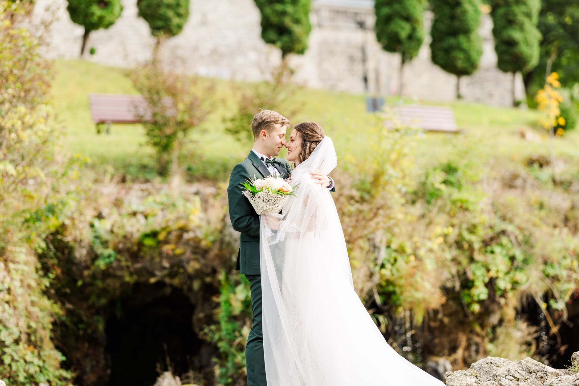 A beautiful couple shares a kiss during their outdoor wedding in Bușteni, Romania.